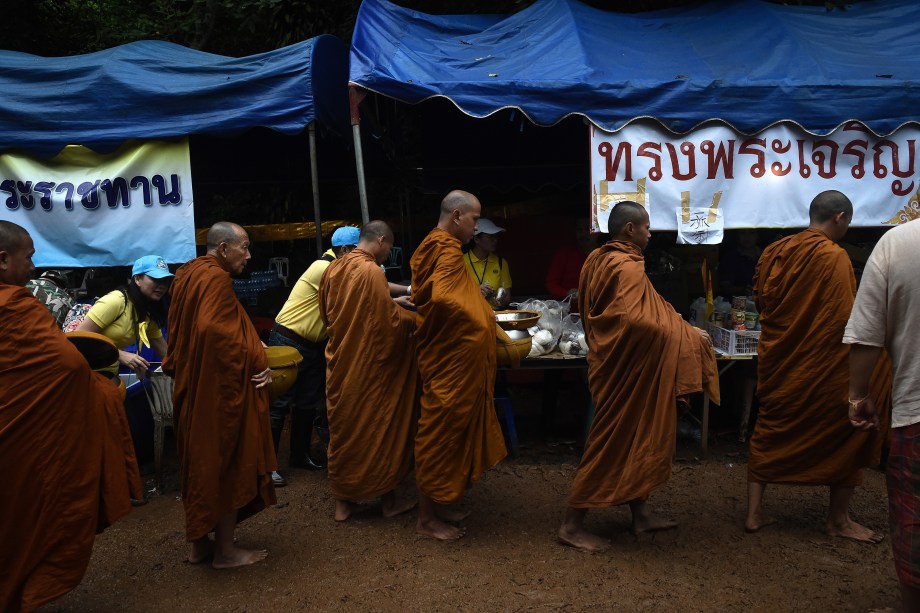 Monges budistas coletam esmolas no centro de comando perto da caverna de Tham Luang, após notícias de que todos os membros do time de futebol infantil e seu técnico estavam vivos - 02/07/2018