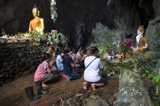 Familiares rezam em um santuário do lado de fora do complexo de cavernas de Tham Luang, antes do resgate dos jovens presos na caverna inundada em Chiang Rai, na Tailândia - 05/07/2018