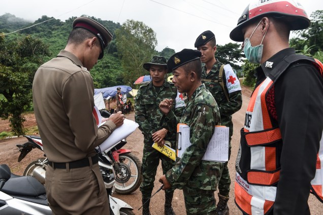 Policial tailandês fala com um soldado na área externa do complexo de cavernas Tham Luang durante as operações de resgate dos 12 meninos e seu treinador presos no local - 08/07/2018