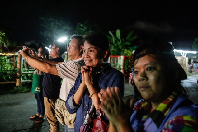 Pessoas aplaudem o momento em que as ambulâncias transportam os meninos resgatados da caverna, na província de Chiang Rai, norte da Tailândia - 08/07/2018
