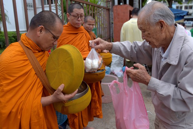 Homem oferece comida a monges budistas perto do hospital onde os meninos resgatados depois de ficarem presos em uma caverna próxima por quase duas semanas foram levados para observação, na cidade de Chiang Rai, no norte da Tailândia - 09/07/2018