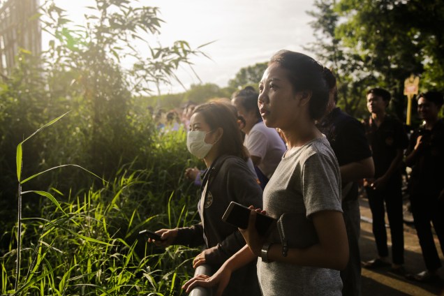 Pessoas assistem e aplaudem enquanto as ambulâncias transportam alguns dos estudantes resgatados do complexo de cavernas Tham Luang para um hospital em Chiang Rai, norte da Tailândia - 09/07/2018