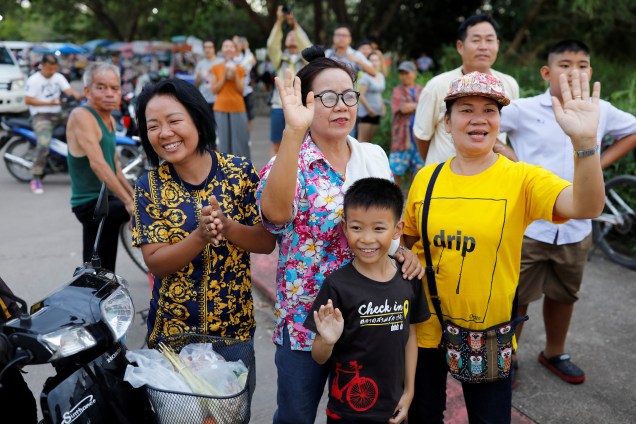 Espectadores acenam enquanto uma ambulância carregando estudantes resgatados da caverna deixa um aeroporto militar em Chiang Rai, norte da Tailândia - 10/07/2018