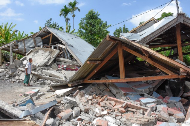 Homem examina os escombros das casas, após um terremoto de magnitude 6,4, atingir a ilha de Lombok, na Indonésia - 29/07/2018