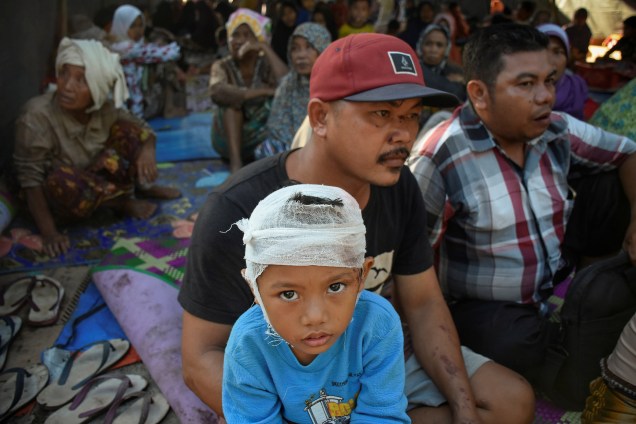 Sobreviventes do terremoto sentam-se em uma tenda improvisada na aldeia de Sambelia em Lombok Timur - 30/07/2018