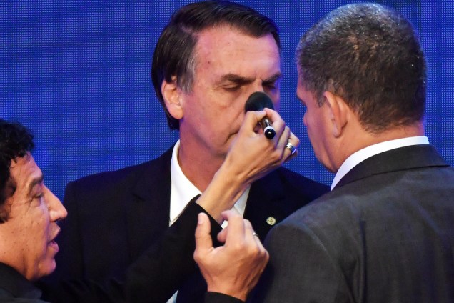 O candidato Jair Bolsonaro (PSL) recebe retoques na maquiagem enquanto conversa com seus assessores, durante o debate presidencial promovido pela TV Bandeirantes - 10/08/2018