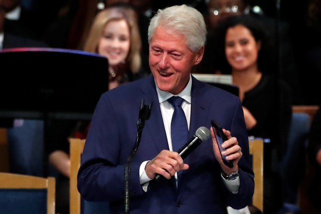 O ex-presidente americano Bill Clinton, reproduz em seu celular uma música da cantora Aretha Franklin, durante funeral em Detroit - 31/08/2018