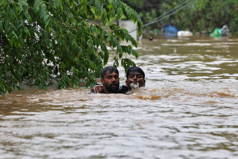 Homem que estava se afogando é resgatado em uma área alagada após a abertura das barragens de Idamalayr, Cheruthoni e Mullaperiyar, nos arredores de Kochi, Índia - 16/08/2018