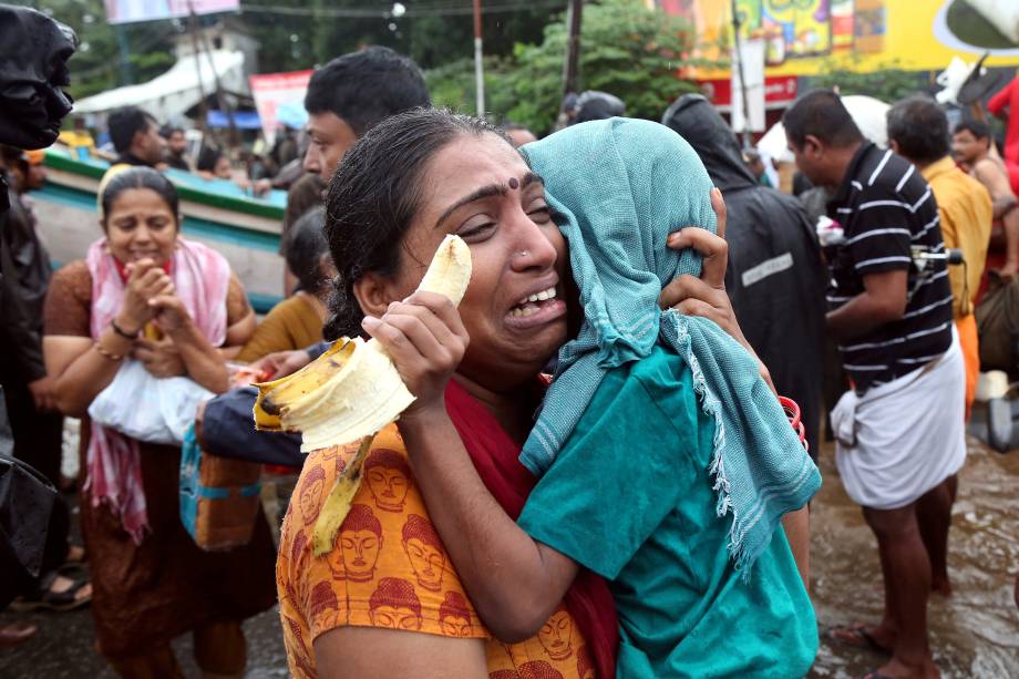 Mulher chora com seu filho no colo depois de terem sido resgatados de uma área alagada em Aluva, no estado de Kerala, sul da Índia - 18/08/2018