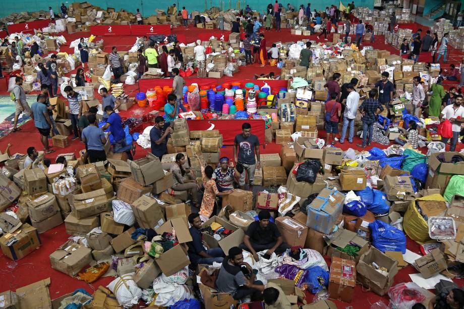 Voluntários trabalham em um centro de distribuição de ajuda dentro de um estádio em Kochi, no sul do estado indiano de Kerala - 19/08/2018