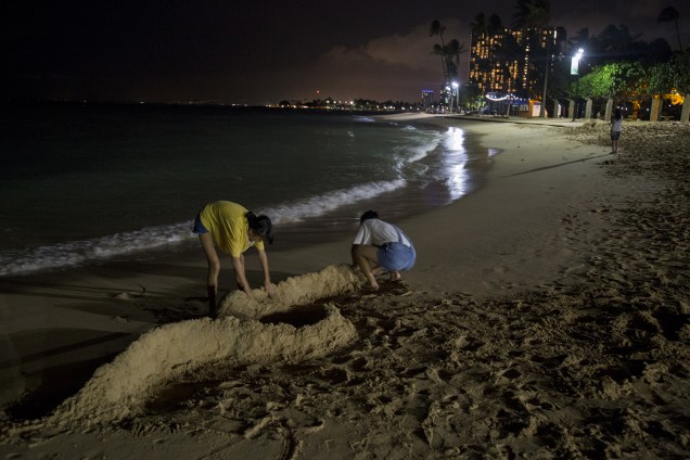 Turistas fazem barreiras com areia, antes da passagem do furacão Lane na praia de Waikiki, em Honolulu, Havaí - 23/08/2018