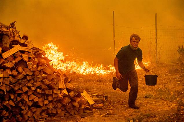 Alex Schenck tenta salvar sua casa de incêndio florestal no Complexo Mendocino, Califórnia - 04/08/2018