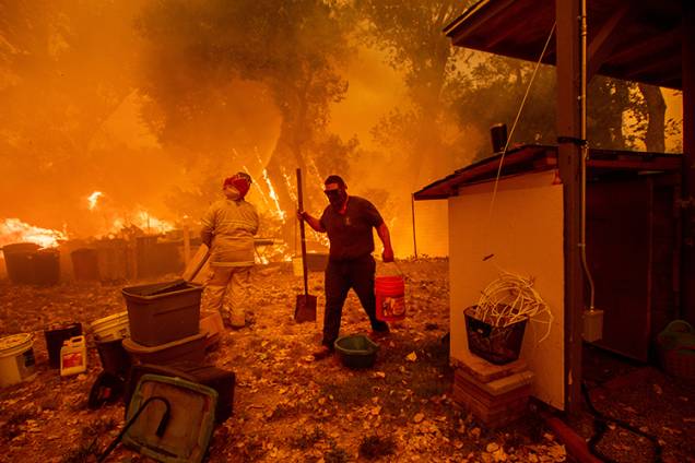 Lane Lawder, morador de área próxima a cidade de Clearlake Oaks tenta salvar sua casa de incêndio na Califórnia - 04/08/2018