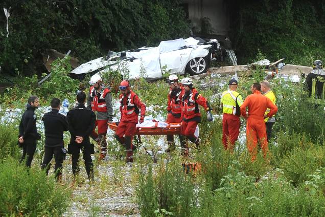 Equipes de resgate retiram um corpo dos escombros da Ponte Morandi que entrou em colapso na cidade portuária de Gênova, na Itália - 14/08/2018