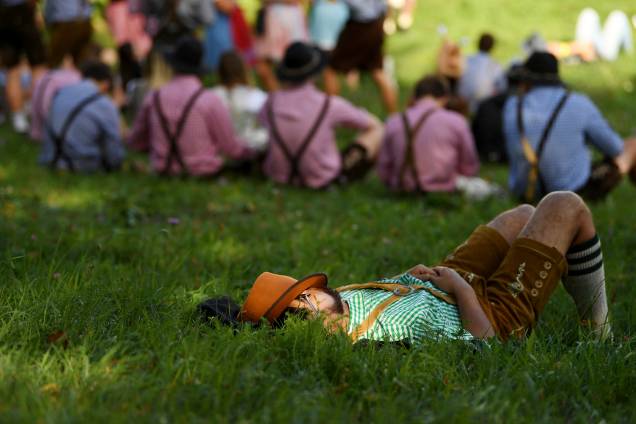 Um participante da 185º Oktoberfest de Munique, na Alemanha, descansa deitado na grama - 22/09/2018 Um participante da 185º Oktoberfest de Munique, na Alemanha, descansa deitado na grama - 22/09/2018