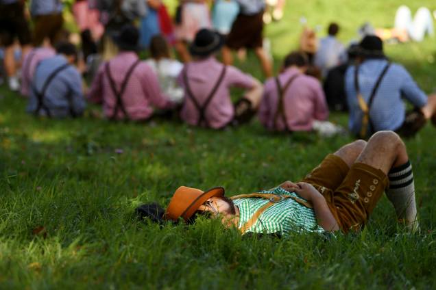 Um participante da 185º Oktoberfest de Munique, na Alemanha, descansa deitado na grama  - 22/09/2018