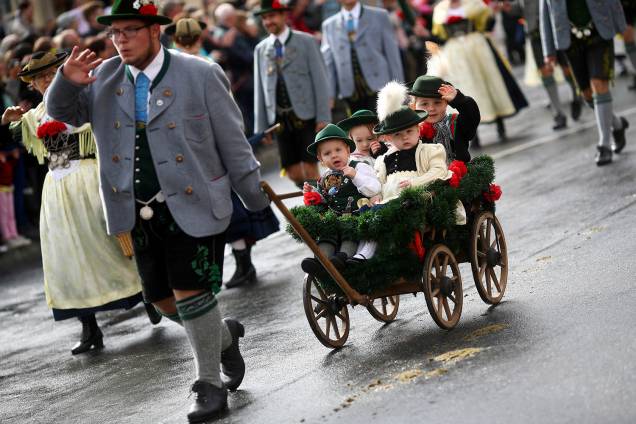Homem vestido com roupas tradicionais dos bávaros carrega seus filhos em uma carrocinha durante um desfile da Oktoberfest 2018, em Munique, na Alemanha - 23/09/2018 Homem vestido com roupas tradicionais dos bávaros carrega seus filhos em uma carrocinha durante um desfile da Oktoberfest 2018, em Munique, na Alemanha - 23/09/2018