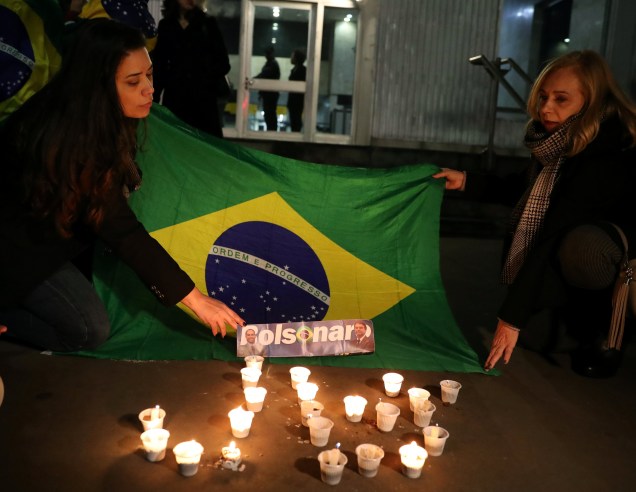 Mulheres esticam uma bandeira do Brasil em frente ao hospital da Santa Casa, em Juiz de Fora, Minas Gerais em homenagem ao presidenciável Jair Bolsonaro, após um atentado com faca - 06/09/2018
