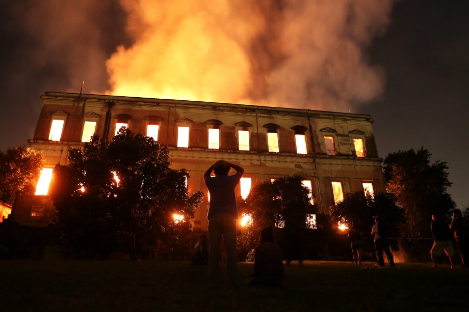 Pessoas acompanham o trabalho dos bombeiros na tentativa de extinguir um incêndio de grandes proporções no prédio do Museu Nacional, no Rio de Janeiro - 02/09/2018