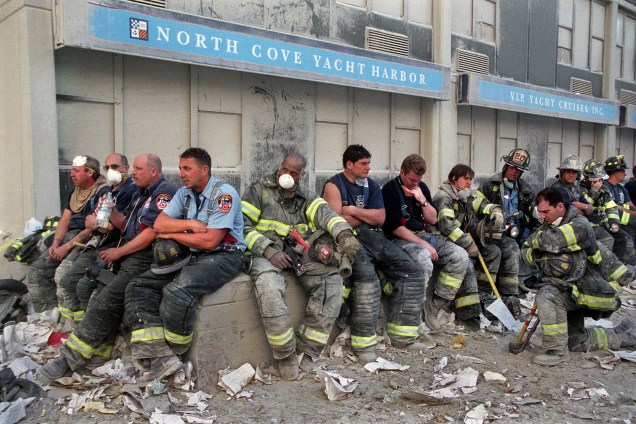 Bombeiros descansam durante operação de resgate das vítimas após o colapso das torres do World Trade Center, alvo de ataque terrorista - 11/09/2001