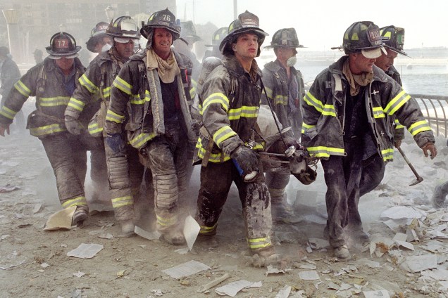 Bombeiros de Nova York carregam o corpo de seu colega  Al Fuentes, ferido no colapso das torres gêmeas do World Trade Center - 11/09/2001