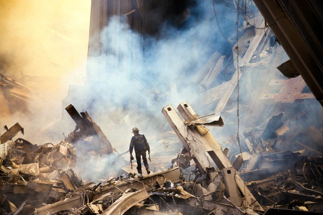 Bombeiro caminha nos escombros das Torres Gêmes destruídas durante ataque terrorista em 11 de setembro de 2001 em Nova York