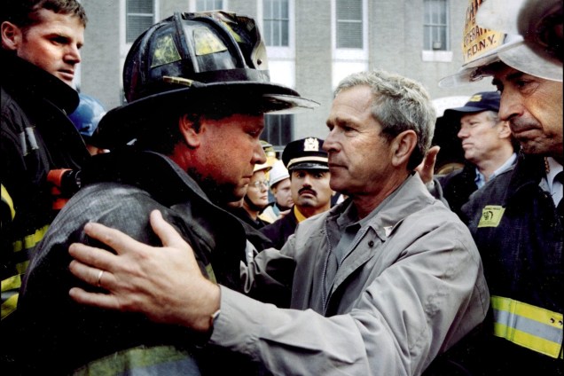 O presidente George W. Bush conforta o bombeiro Lenard Phelan, que perdeu seu irmão, também bombeiro durante as operações de resgate no World Trade Center - 14/09/2001