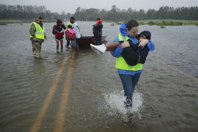 Voluntários auxiliam no resgate de uma criança e sua família em uma região inundada em James City, na Carolina do Norte - 14/09/2018