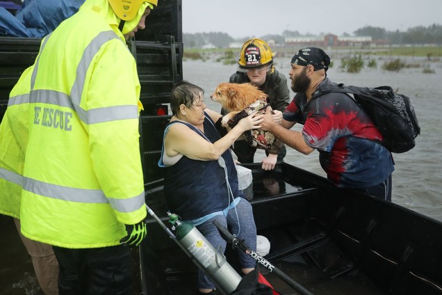 Equipes de resgate e voluntários ajudam a resgatar uma mulher e seu cachorro de sua casa inundada durante passagem do furacão Florence em James City, na Carolina do Norte - 14/09/2018