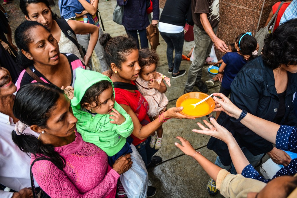Crianças esperam por comida em uma fila de distribuição de sopa nas ruas de Caracas, na Venezuela - 05/11/2017