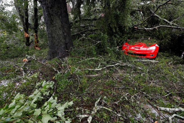 Carro esportivo fica coberto por galhos de árvores derrubadas pela passagem do Furacão Florence em Wilmington, Carolina do Norte - 14/09/2018