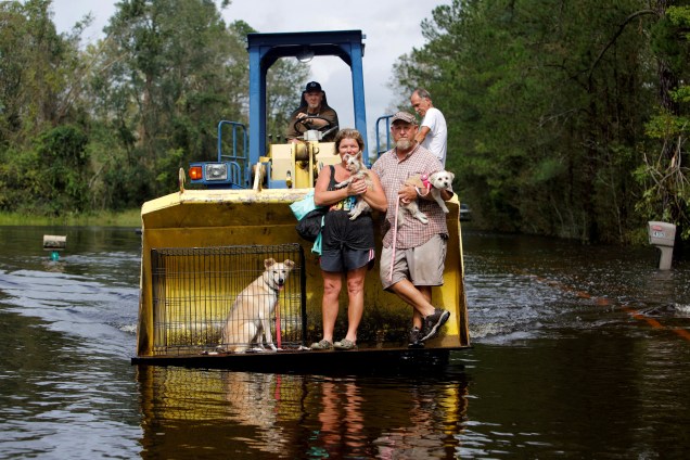 Homem usa seu trator para transportar sua família e animais de estimação em meio a enchente provocada pela passagem do furacão Florence em Burgaw, na Carolina do Norte - 17/09/2018
