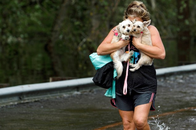 Mulher abraça seus cães de estimação após ser retirada de uma região inundada em Burgaw, na Carolina do Norte - 17/09/2018