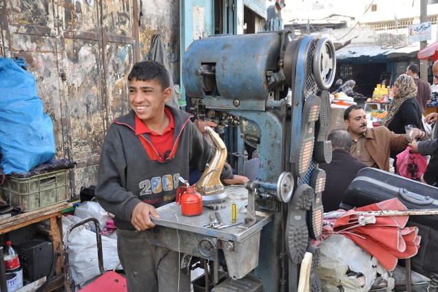 Garoto faz solas de sapato em máquina, na região de Gaza: raro emprego.
