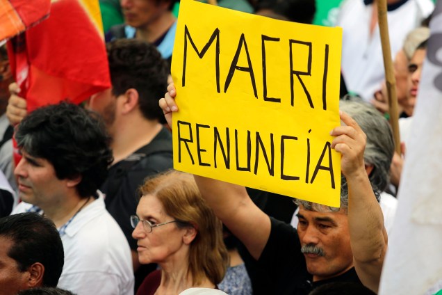 Homem segura uma placa que diz "Macri renuncie" durante um protesto contra a política econômica do presidente argentino em Buenos Aires - 24/09/2018