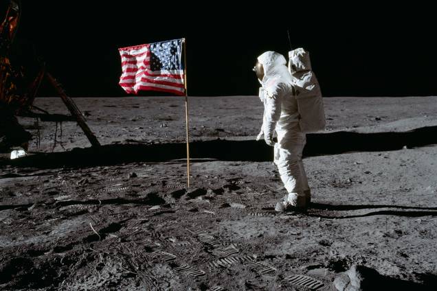 O astronauta Neil Armstrong saudando a bandeira americana após aterrissar em solo lunar