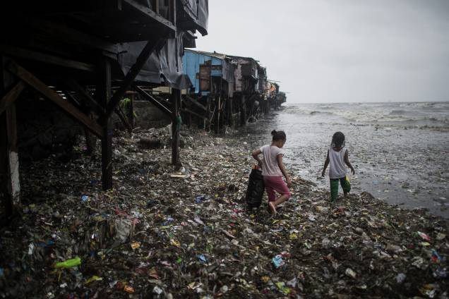 Crianças coletam materiais recicláveis trazidos pelas fortes ondas causadas pela passagem do supertufão Mangkhut em Manila nas Filipinas - 15/09/2018