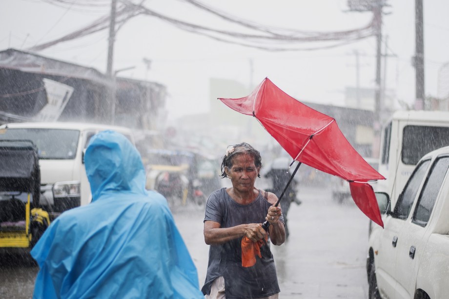Mulher tem seu guarda-chuva destruído durante as fortes tempestades causadas pelo supertufão Mangkhut em Manila nas Filipinas - 15/09/2018