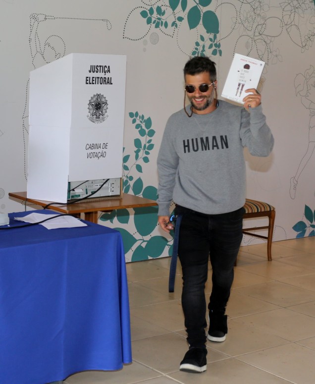 Bruno Gagliasso votando com livro