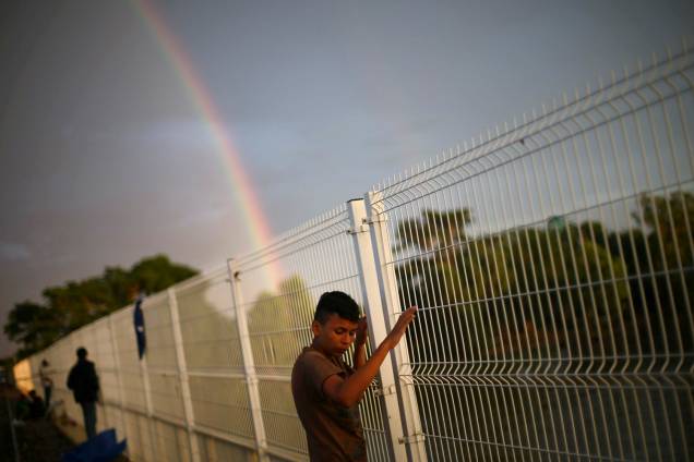 Imigrante que aguarda para seguir viagem até os Estados Unidos é fotografado junto com um arco-iris em Ciudad Hidalgo, no México - 21/10/2018