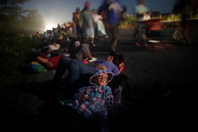 Glenda Escobar, 33, uma imigrante de Honduras deita com seu filho Adonei na beira de uma estrada durante uma caravana de milhares de latino-americanos rumo aos Estados Unidos, em seu caminho para Pijijiapan de Mapastepec, no México - 25/10/2018