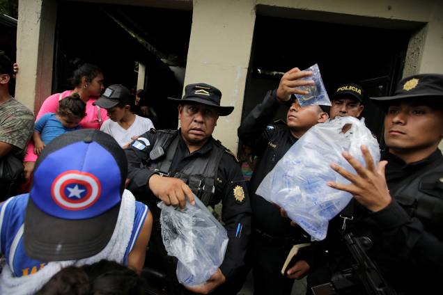 Policiais da Guatemala distribuem água para imigrantes participantes de caravana com destino aos Estados Unidos - 15/10/2018 Policiais da Guatemala distribuem água para imigrantes participantes de caravana com destino aos Estados Unidos - 15/10/2018