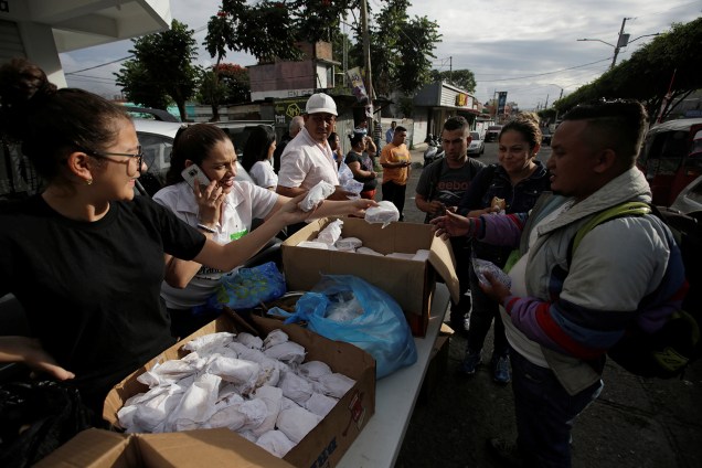 Voluntários distribuem comida para imigrantes de Honduras que participam de caravana com destino aos Estados Unidos - 16/10/2018