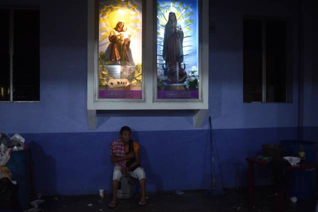Jjovem, integrante de um grupo de migrantes hondurenhos que segue em caravana para os Estados Unidos, fica na "Igreja das Três Caidas", em Tecun Uman, na fronteira com o México - 18/10/2018