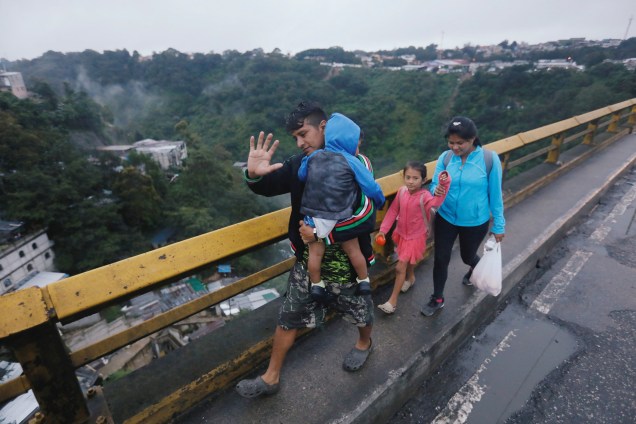 Imigrantes hondurenhos, parte de uma caravana que tenta chegar aos Estados Unidos, caminham em uma ponte durante sua viagem na Cidade da Guatemala, Guatemala - 18/10/2018