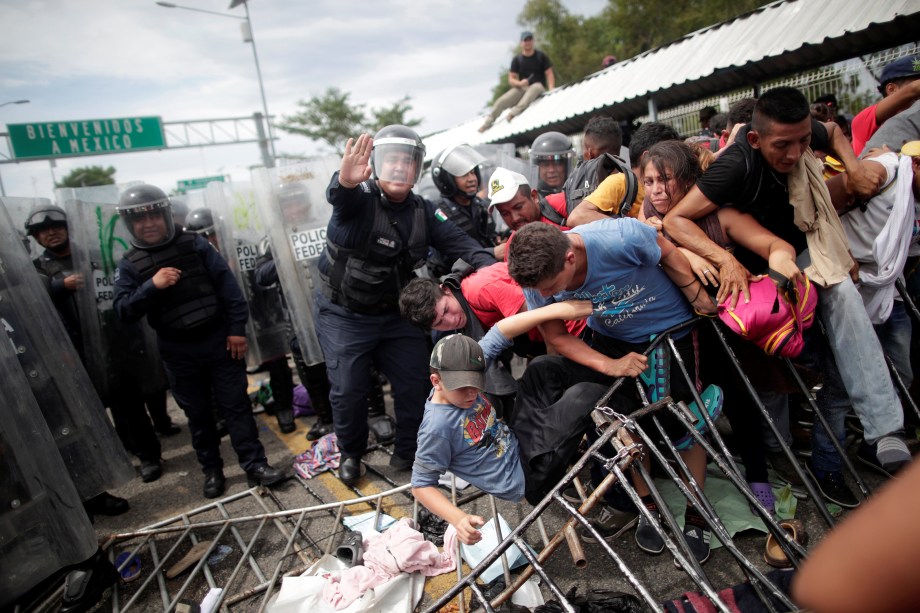 Policiais tentam conter um enorme grupo de imigrantes hondurenhos que tentavam atravessar a fronteira da Guatemala para entrar no México, em Ciudad Hidalgo - 20/10/2018