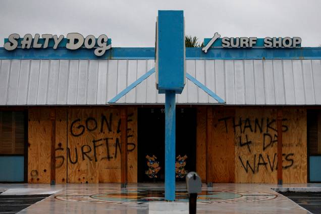 Uma mensagem de agradecimento às grandes ondas é vista em uma proteção de madeira nas portas de uma loja de surfe, em Panama City Beach, na Flórida, antes da chegada do furacão Michael - 10/10/2018