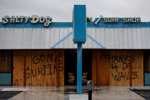 Uma mensagem de agradecimento às grandes ondas é vista em uma proteção de madeira nas portas de uma loja de surfe, em Panama City Beach, na Flórida, antes da chegada do furacão Michael - 10/10/2018
