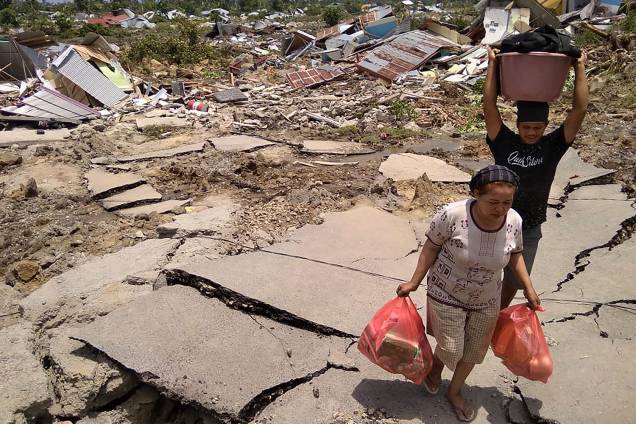 Residentes de Palu, a cidade mais afetada pelo terremoto seguido de tsunami em Sulawesi, na Indonésia, carregam mantimentos após os tremores - 29/09/2018