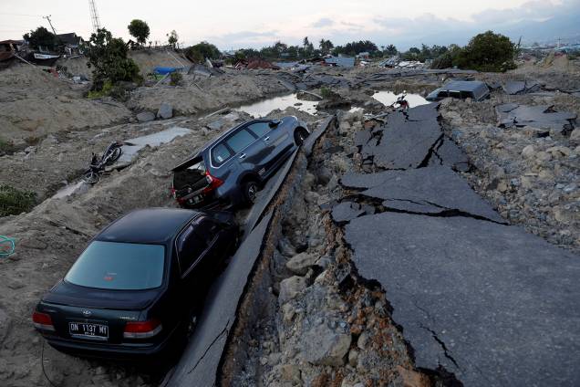 Carros são vistos em uma vala após a destruição do terreno em que estavam durante o terremoto que atingiu Palu, na Indonésia - 01/10/2018